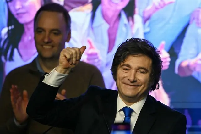 Adorni está detrás de un Milei sonriente
