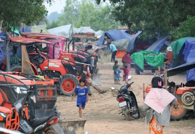 A child runs next to tractors at a refugee camp after evacuation, amid deadly clashes between Thailand and Cambodia along a disputed border area, in Srei Snam, Siem Reap Province, Cambodia, December 10, 2025. REUTERS/Kim Hong-Ji