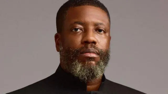 Man wit beard look di camera