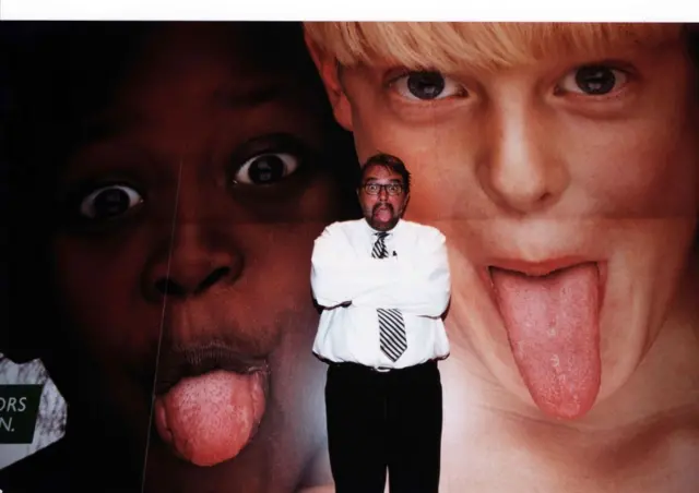 El fotógrafo italiano Oliviero Toscani posa delante de una foto suya para la campaña publicitaria de Benetton. Roma.