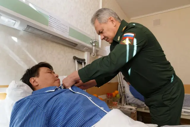Шойгу награждает раненого военного в госпитале