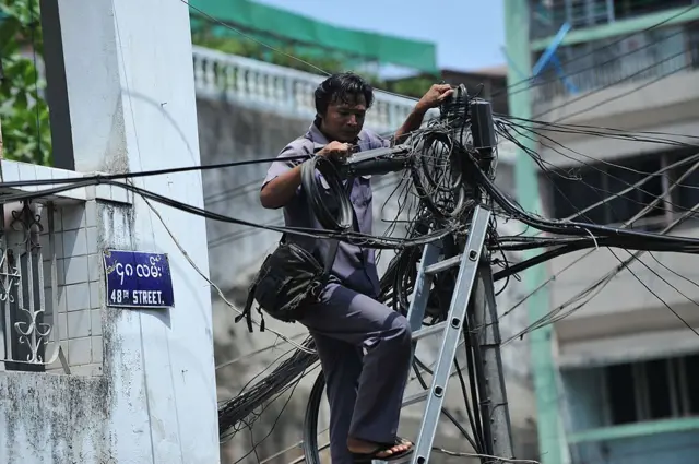 ၂၀၁၃ ခုနှစ်တုန်းက ရန်ကုန်မြို့မှာ ဓာတ်တိုင်က ကေဘယ်ကြိုးတွေကိုစစ်ဆေးနေတဲ့ လျှပ်စစ်ဝန်ထမ်းတစ်ဦး 