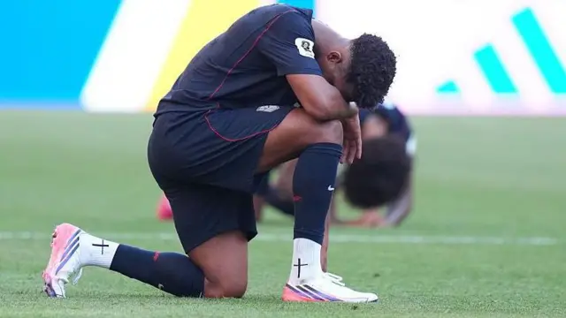 Jugador estadounindese de rodillas después de la derrota frente a Belgica.