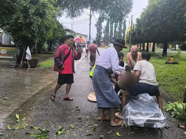 သြဂုတ် ၂၄ ရက်၊ သီပေါမြို့၊ ရွှေကျောင်းရပ်ကွက်မှာ လက်နက်ကြီးထိသူကို ထမ်းစင်ပေါ် တင်ပြီး အမျိုးသား ၆ ဦးက ကယ်ဆယ်ရေးလုပ်နေပါတယ်။ 