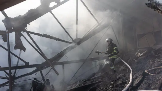 Equipes do serviço de emergência ucraniano apagando incêndio em uma fábrica após um bombardeio russo em Kostiantinivka, na Ucrânia.