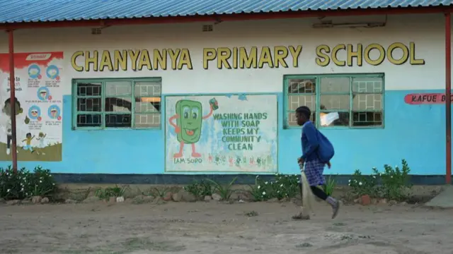 Un élève passant devant un bâtiment scolaire