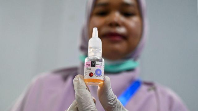 Seorang petugas kesehatan menunjukkan vaksin polio saat program vaksinasi di sebuah sekolah di Banda Aceh