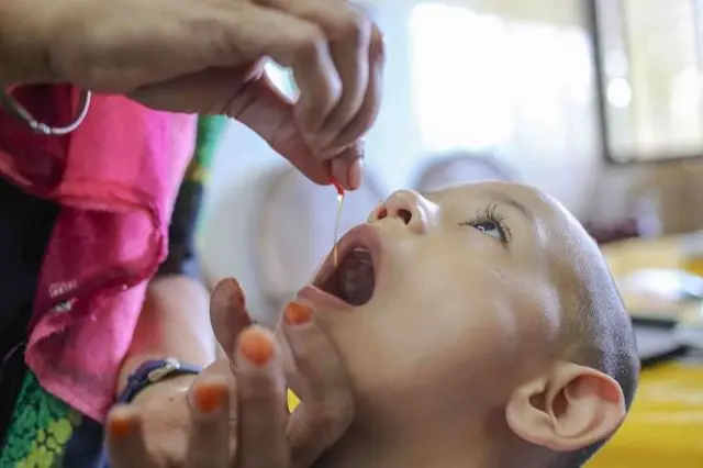 একটি শিশু হা করে ক্যাপসুল খাচ্ছে