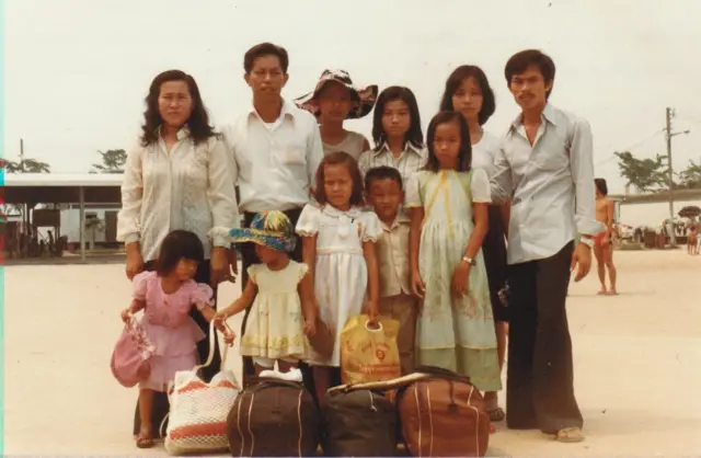 Bà Trần Thị Oanh, lúc đó 2 tuổi, mặc váy hồng, cùng gia đình và người quen tại trại tị nạn do UNHCR quản lý ở Malaysia vào năm 1982 Bà Trần Thị Oanh, lúc đó 2 tuổi, mặc váy hồng, cùng gia đình và người quen tại trại tị nạn do UNHCR quản lý ở Malaysia vào năm 1982