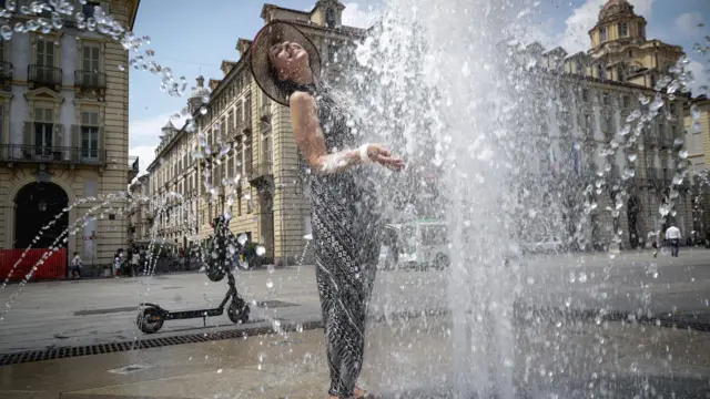 Žena se rashlađuje na trgu u Torinu, na severu Italije