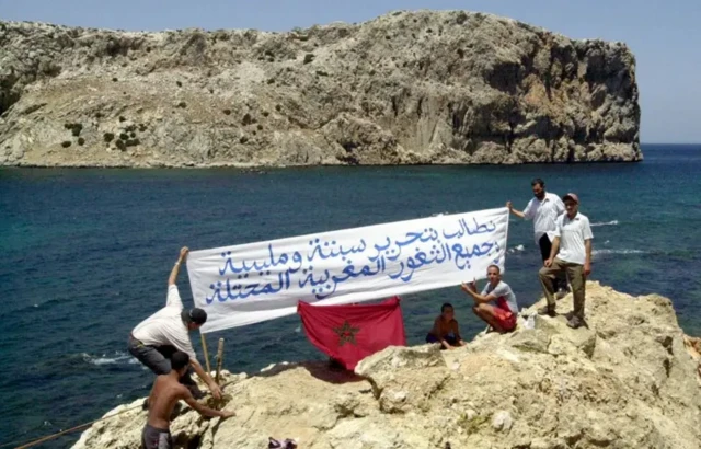 معترضان مراکشی در ۲۱ ژوئیه ۲۰۰۲، در ساحل مراکش مقابل جزیره کوچک پرخیل، بنری را در دست دارند که روی آن نوشته شده است: «خواستار آزادی سبته، ملیله و تمام سرزمین‌های اشغال‌شده مراکش هستیم.» 