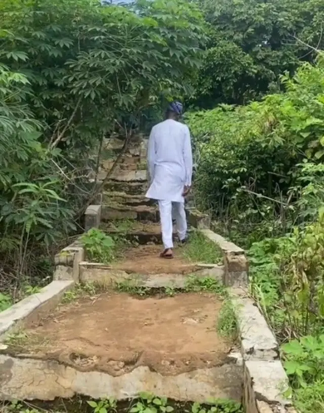 Ọkunrin kan to wọ asọ funfun, de fila ẹtu, n gun ori oke lọ