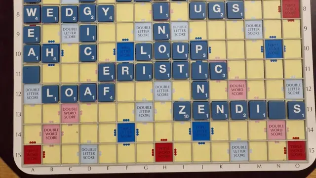 Un tablero de Scrabble amarillo muestra palabras escritas con fichas azules y letras blancas. Algunos de los bosques incluyen loaf, wedgy, loup, eristic y wedgy.