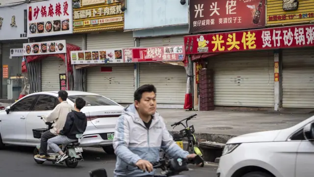 一名男子骑着电动自行车在马路上逆行。