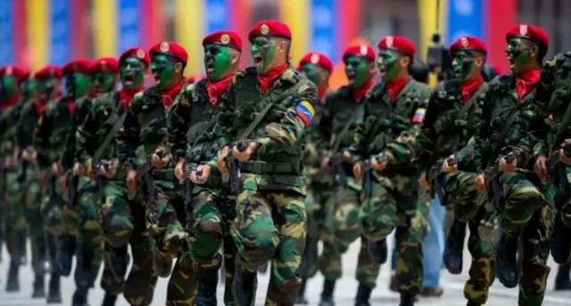Kırmızı bereli Venezuela askerleri bir geçit töreninde tam kamuflajlı olarak görülüyor