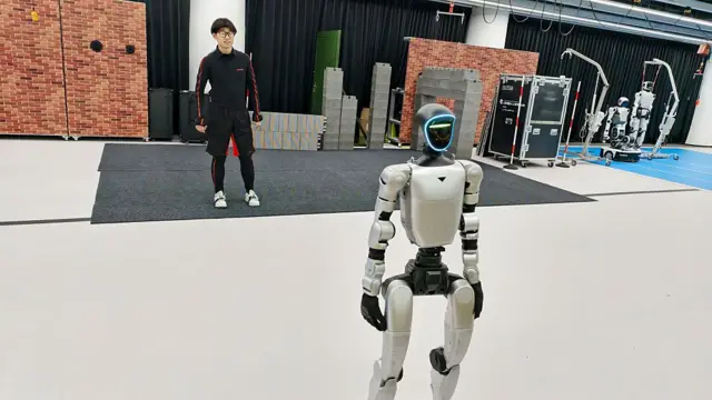 Una persona entrenando a un androide en las instalaciones de Unitree