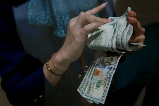 Karyawan menghitung uang pecahan dolar Amerika Serikat (AS) di gerai penukaran mata uang asing Haji La Tunrung, Makassar, Sulawesi Selatan, Rabu (20/05).