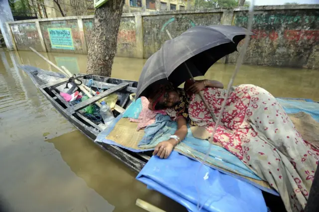 ডায়রিয়া আক্রান্ত এক নারীকে নৌকায় করে হাসপাতালে নিয়ে যাওয়া হচ্ছে।