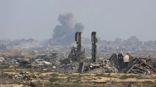 গাজায় ভবনের ধ্বংসস্তূপে একটি জায়গা থেকে ধোঁয়া উড়ছে