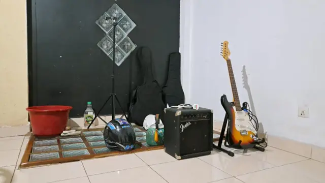 සාලයේ එක් පසෙක ඔවුන්ගේ සංගීත භාණ්ඩ තබා තිබුණු ස්ථානයේ බිම බේසමක් තබා තිබුණේ, අබලන් වී ඇති වහලයෙන් වැටෙන වැහි බිඳු බිම පතිත වීම වැළැක්වීමට ය.