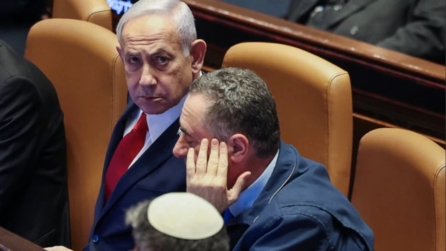 İsrail Başbakanı Binyamin Netanyahu meclisteki bir oturumda fotoğraflanmış. Kameraya bakıyor.
