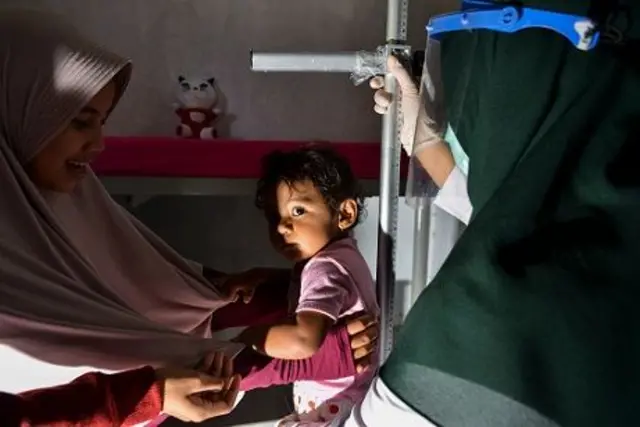 Petugas kesehatan mengukur balita sebelum diberikan vaksin tuberkulosis dan polio di pos pelayanan terpadu di Banda Aceh pada 11 Agustus 2020.