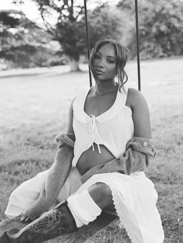 Temi Otedola Ajibade siddon under tree , she wear white cloth wey dey show her baby bump.