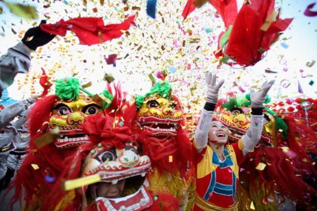 Artistas folclóricos chinos interpretan la danza del león en la feria de un templo para celebrar el Año Nuevo Lunar. 