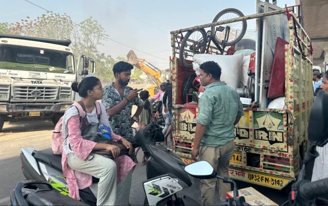 सामान के साथ घर शिफ़्ट करने की जद्दोजहद में खुशबू (स्कूटी पर)