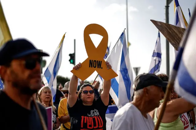 Elinde "şimdi" yazılı bir pankart taşıyan İsrailli bir kadın