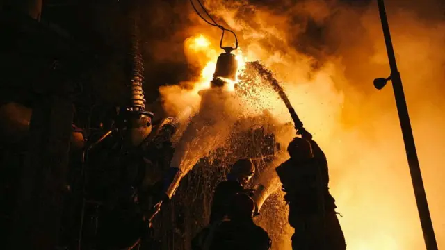 Firefighters work at a site of a critical power infrastructure object, which was hit during Russia's drones attacks in Kyiv, Ukraine, in this handout picture released December 19, 2022