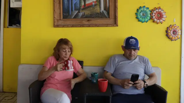 Rosa y su hijo Edgar toman café en el jardín de su casa de Mexicali. 