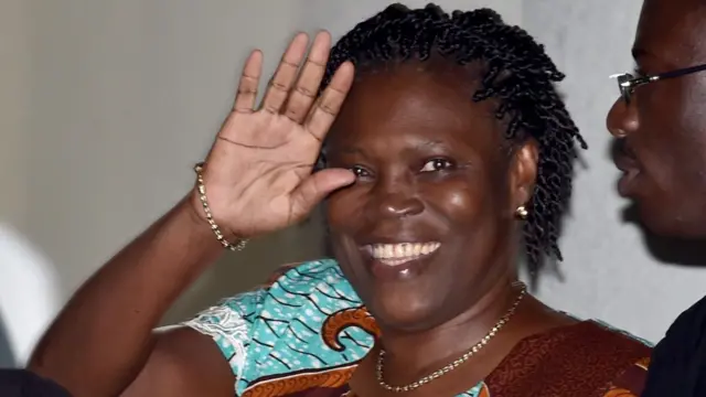 L'ancienne première dame de Côte d'Ivoire, Simone Gbagbo, sourit et fait un signe de la main.