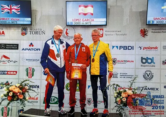 Juan en lo más alto del podio, recibiendo una medalla de oro en una prueba de 3.000 mts