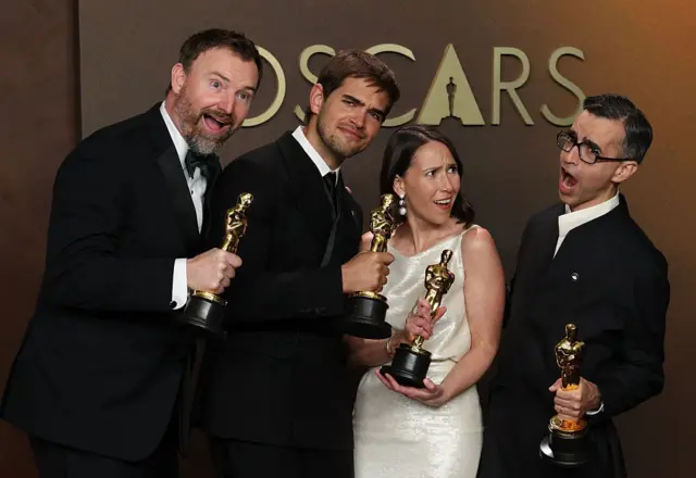 Quatro pessoas segurando estatuetas do Oscar