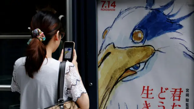 Žena fotografiše poster za film „The Boy and the Heron"