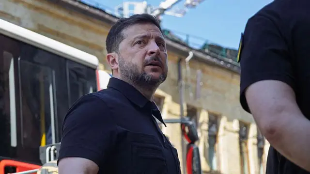 Владимир Зеленски у црној мајици, усликан напољу, док гледа у даљини