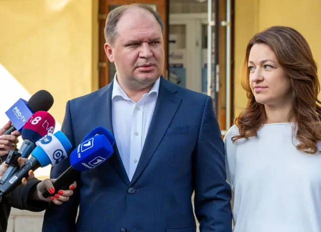 Мер Кишинева Іон Чебан у синьому костюмі (ліворуч) та його дружина Тетяна у білому костюмі (праворуч) відповідають на запитання журналістів після голосування на місцевих виборах