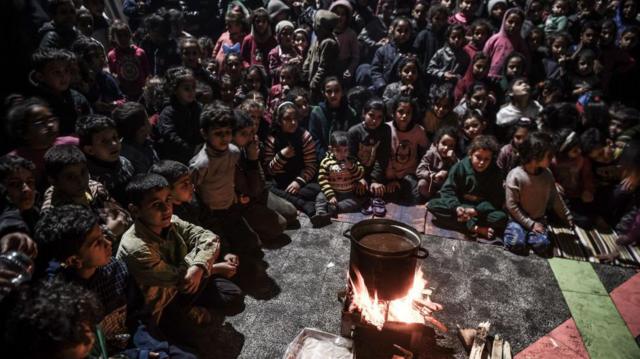فلسطینی‌هایی که برای نجات جانشان از خانه‌هایشان گریخته‌اند، در مدرسه‌ای در جنوب این باریکه در رفح برای کودکان جشن شب معراج پیامبر اسلام برپا کرده‌اند