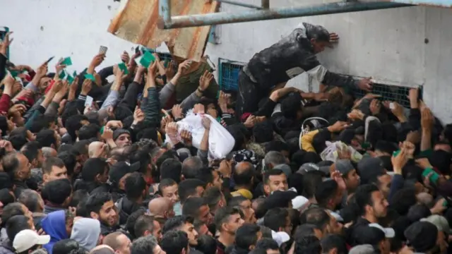 فلسطينيون يحتشدون لتلقي مساعدات خارج مستودع لأونروا في غزة - 18 مارس/آذار 2024