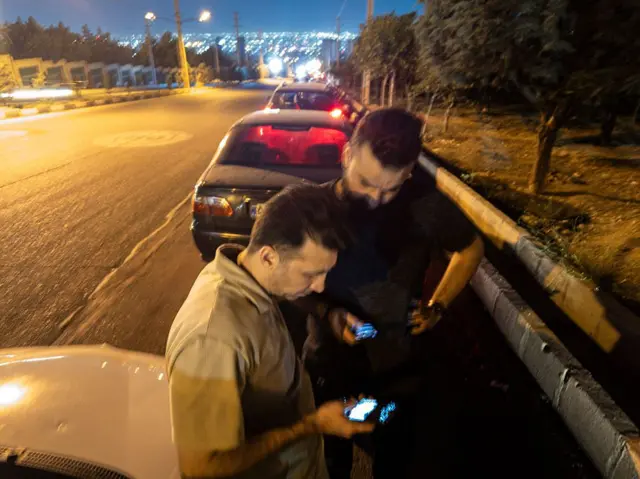 دو نفر در حال تماشای گوشی موبایل