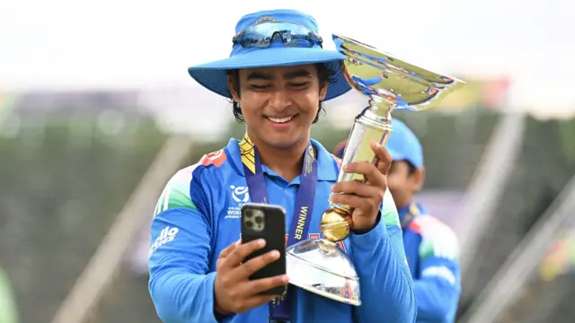 ২০২৬ সালের অনূর্ধ্ব-১৯ বিশ্বকাপ ট্রফি হাতে বৈভব সূর্যবংশী ফোনে সেলফি তুলছেন - ফাইল ছবি
