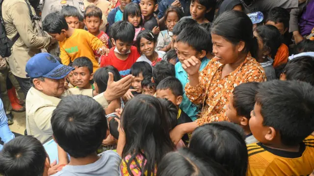 Presiden Prabowo Subianto (kiri) menyapa anak-anak saat mengunjungi posko pengungsian di Kuala Simpang, Aceh Tamiang, Aceh, Jumat (12/12/2025).