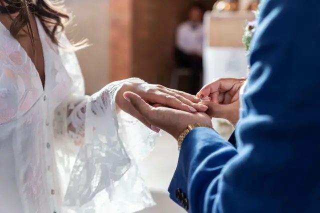 Couples heureux de mariage retenant leurs anneaux de fiançailles. concept de mariage et d’amour.