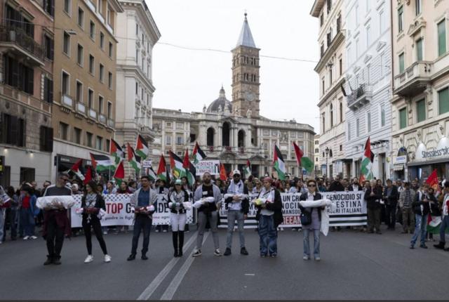 متظاهرون يحملون جثثاً وهمية وأعلاماً فلسطينية خلال مظاهرة لدعم الشعب الفلسطيني في روما، إيطاليا