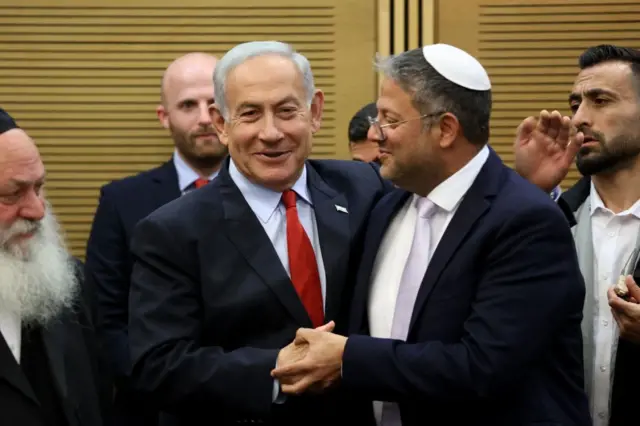 Benjamín Netanyahu e Itamar Ben-Gvir se dan la mano y palmaditas en la espalda.