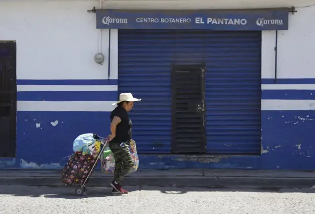 Una mujer pasa por el bar donde un grupo armado asesinó a 12 personas al abrir fuego contra clientes y personal, en Irapuato, estado de Guanajuato, México, el 16 de octubre de 2022. - Doce personas fueron asesinadas en un tiroteo en un bar del centro de México el sábado, según dijeron las autoridades locales, en medio de una creciente violencia de los cárteles que hace de la región una de las más peligrosas del país. (Foto de MARIO ARMAS / AFP) (Foto de MARIO ARMAS/AFP vía Getty Images)