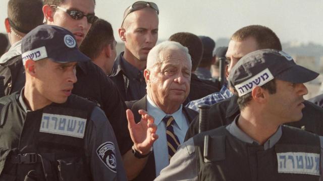 رئيس الوزراء الإسرائيلي آنذاك شارون محاط بالحراس أثناء خروجه من باحة المسجد الأقصى عام 2000.