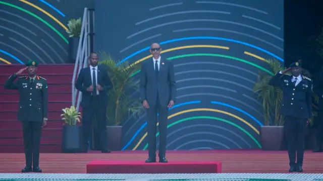 Paul Kagame hagati y'umugaba w'ingabo Gen Mubarakh Muganga (ibumoso) n'umukuru w'igipolisi Inspector General Felix Namuhoranye (iburyo) bahageze imbere y'akarasisi k'ingabo na polisi