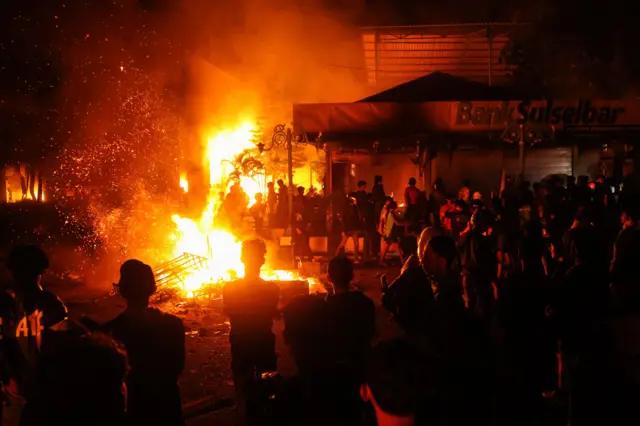 Pengunjuk rasa melihat fasilitas dan gedung DPRD Sulawesi Selatan yang dilalap api saat aksi 29 Agustus di Makassar, Sulawesi Selatan, Sabtu (30/8/2025) dini hari.